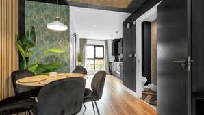 A modern kitchen with dark cabinetry, a wooden countertop, and a built-in oven.