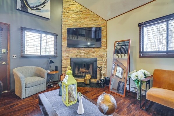 A living room with a fireplace, a sofa, a chair, and a globe on a table.