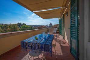 A balcony with a table and chairs, a view of a dome building, and a tiled floor. - Orto Botanico Apartment With Terrace And Dome View Florence (Florence)