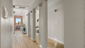 A modern hallway with wooden flooring, white walls, and a brick fireplace. - AS HOME Apartamenty Rynek 50 (Wroclaw)