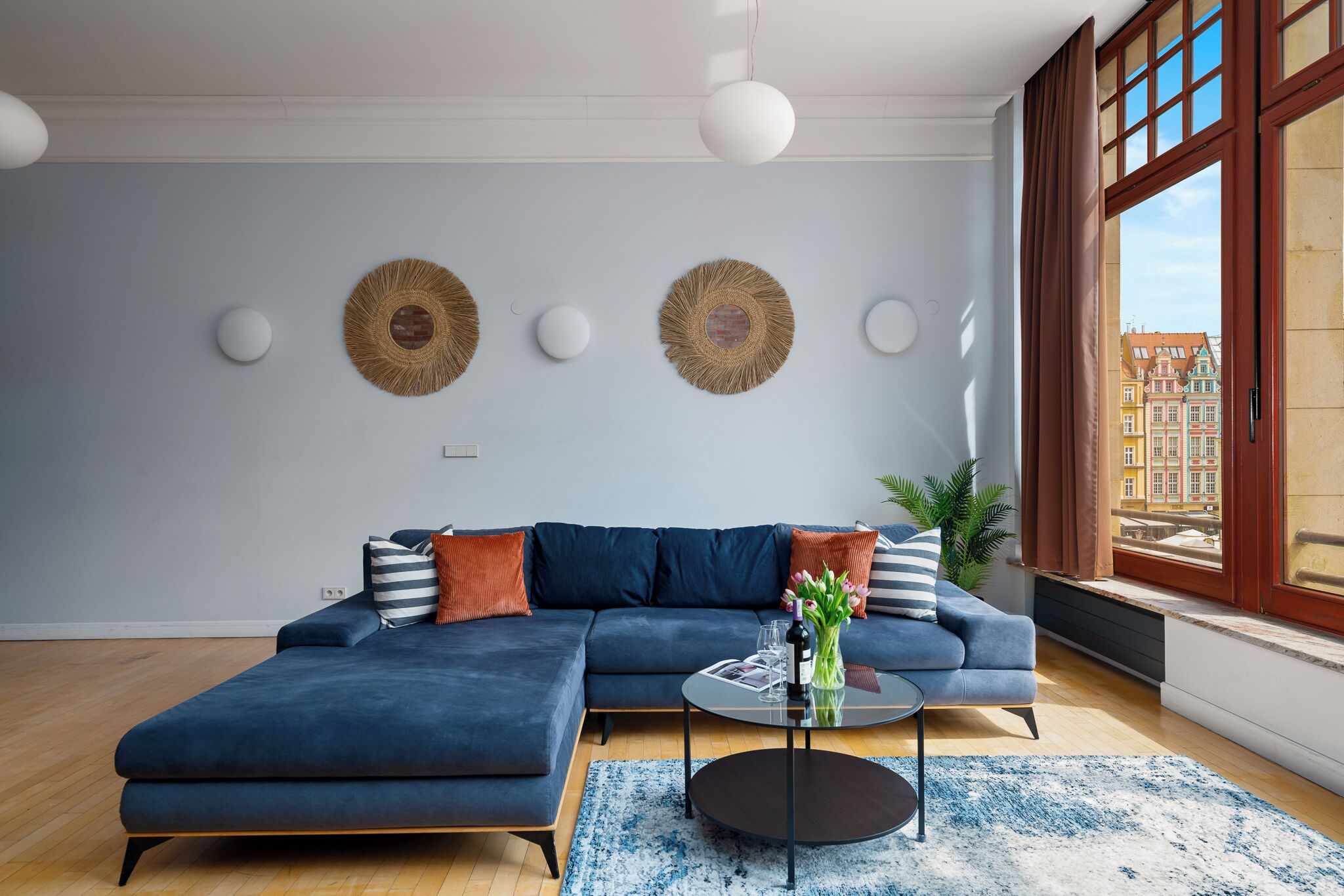 A modern living room with a sectional sofa, a round coffee table, and decorative wall art.