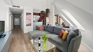 A modern living room with a grey sofa, a glass coffee table, and a staircase leading to an upper level. - AS HOME Apartamenty Rynek 50 (Wroclaw)