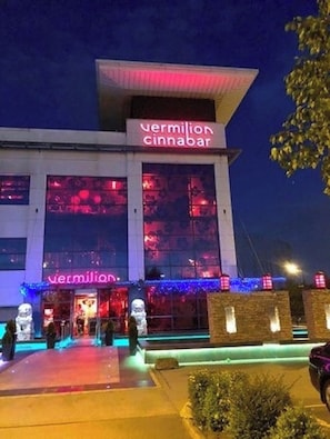 Un edificio de diseño moderno, con amplios ventanales y un letrero llamativo que dice 'vermillion cinnabar'.