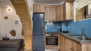 Una cocina moderna con armarios de madera, un refrigerador azul y un horno empotrado.