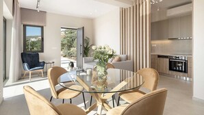 A modern open-plan living space with a dining area, kitchen, and a view of the outdoors. - GG Villas Falassarna (Disability Access) (Chania)