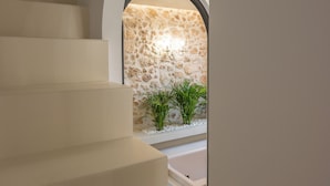 A staircase leading to a stone wall with plants. - Il Campanile Suite for Two (Crete)