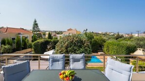 Ein Balkon mit Tisch, Stühlen und einer Obstschale.