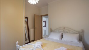 Ein Schlafzimmer mit einem Bett, weißer Bettwäsche und einem Spiegel an der Wand.