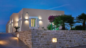A modern building with a stone wall, a paved entrance, and outdoor lighting. - Hannah Villa Stalos: spacious, quiet villa w/sea and mountain view (Chania)