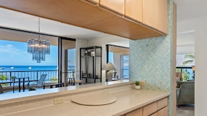 Una cocina moderna con armarios de madera, encimera de granito y vistas al océano.