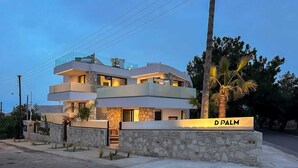 Una casa moderna de varios pisos con fachada de piedra y un letrero que dice 'D PALM PREMIUM LIVING'.