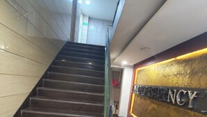 A staircase leading to a reception area with a sign that reads "MOTEL & CONCY". - Hotel Ishaan Residency MGM CLUB (New Delhi)