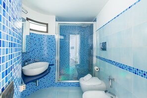 A bathroom with a large white sink, a toilet, and a glass-enclosed shower. - Design Studio Duplex at National Museum (Naples)