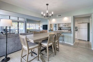 Una cocina moderna con una mesa de comedor y sillas, un ventanal grande y una araña.