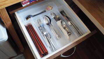 A drawer containing neatly organized cutlery and chopsticks.