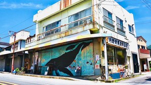 Un edificio a due piani con un murale di un uccello al piano terra.