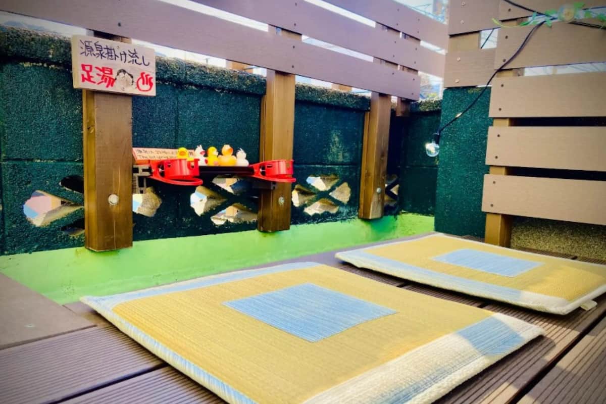 Une pièce avec un sol recouvert de tatamis, un plafond en bois et une inscription en japonais.