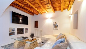 A modern living room with a white leather sofa, a glass coffee table, and a wooden ceiling. - Villa near Ibiza Town, sleeps 13 (Ibiza)