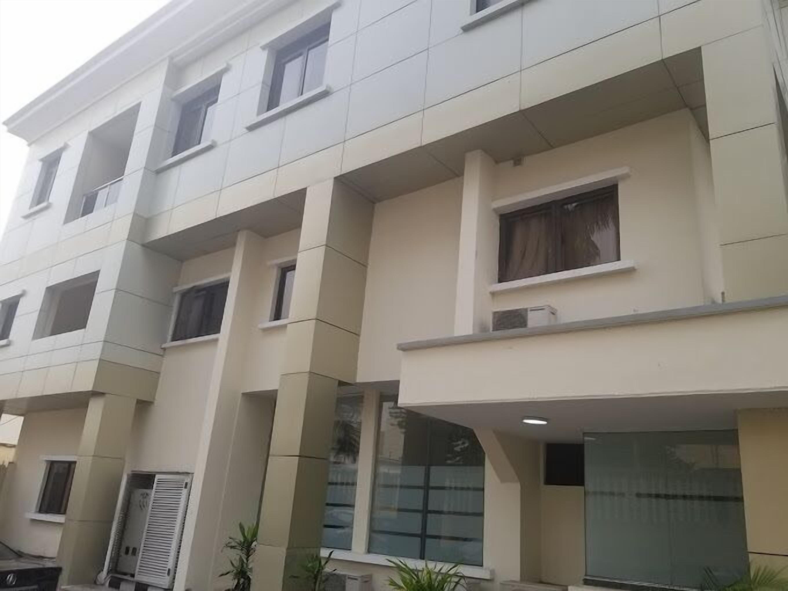 A multi-story building with a modern architectural design, featuring balconies and large windows.