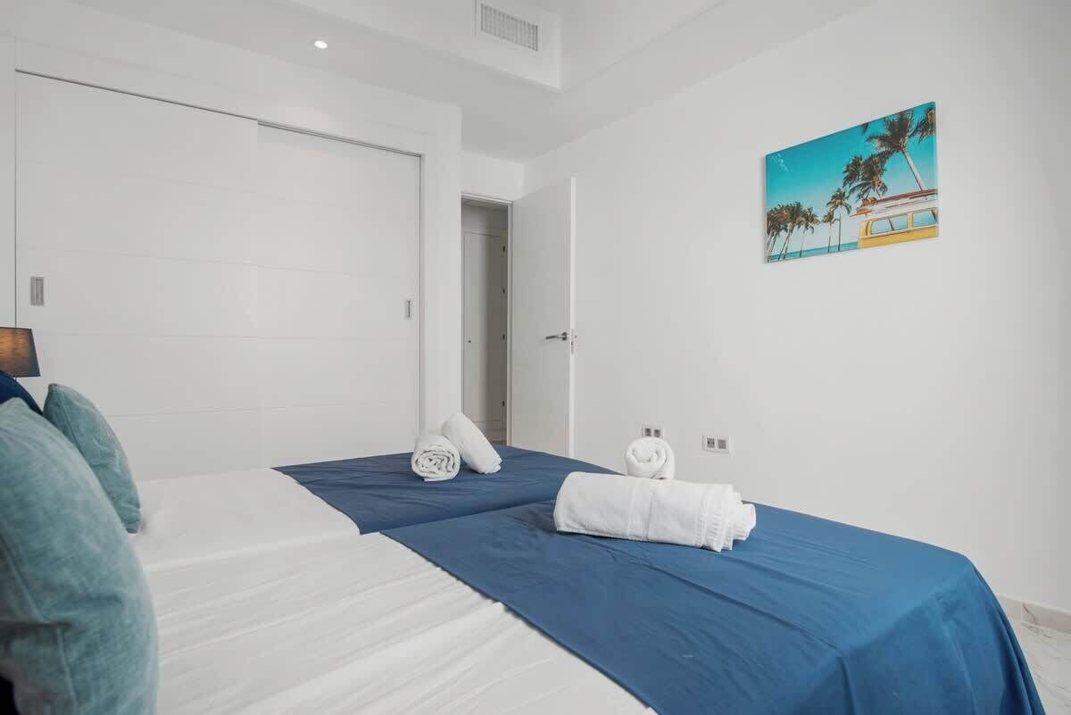 Una camera d'albergo con un letto, una porta e un quadro appeso al muro.