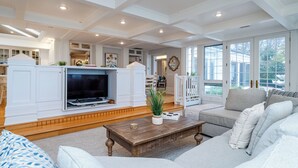 Un salón amplio con chimenea empotrada, un sofá cómodo y una mesa de centro de madera.