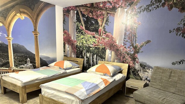A bedroom with two wooden beds, a nightstand, and a sofa. - Beautiful apartment 27b near Mainz University Hospital (Mainz)
