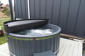 A hot tub with a lid on a wooden deck.