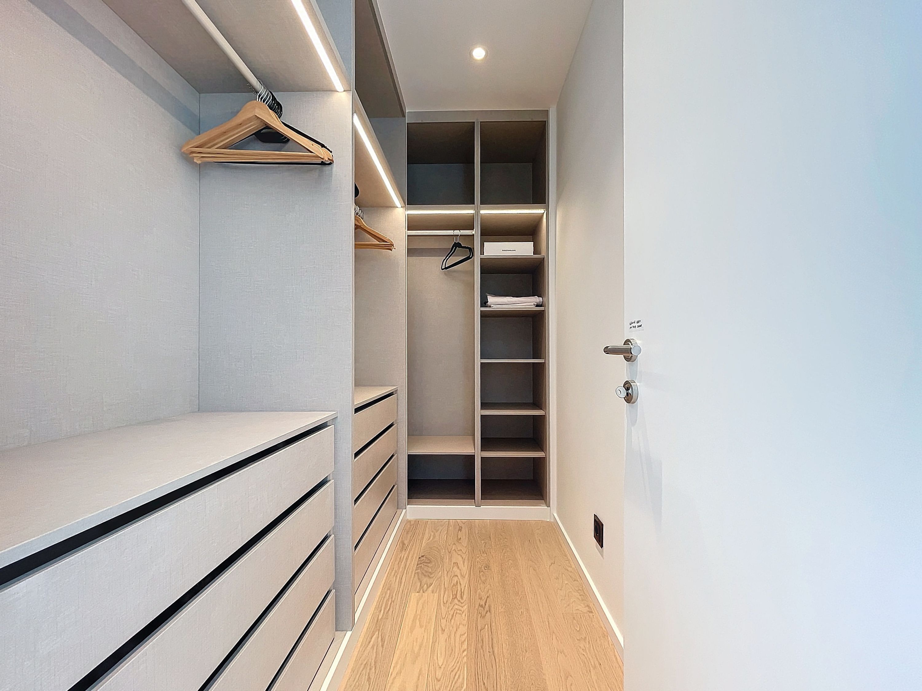 A walk-in closet with open shelving, drawers, and hanging space.