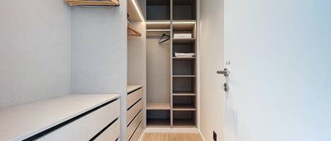 A walk-in closet with open shelving, drawers, and hanging space.