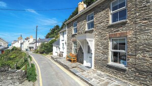 A stone building with a bench outside, a clear road, and a residential area. - Bywell, Llangrannog - Three Bedroom Cottage, Sleeps 6 (Llangrannog)