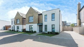 A modern residential building with a brick facade, large windows, and a paved driveway. - Luxurious 4 BH Home Near Willen Lake Ideal for Families & Business Stays! (Milton Keynes)