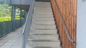 Eine Treppe mit einer Holzverkleidung und Metallgeländer, die zu einer höheren Ebene führt.
