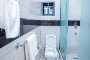 A modern bathroom with a toilet, shower, and a window. - Grovehill Hotel Plus Ilesa  (Ilesa)