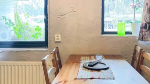 A room with a table, chairs, a window with a view of greenery, and a wall with a nameplate. - 4 Person Holiday Home in Hoor (Hoor)