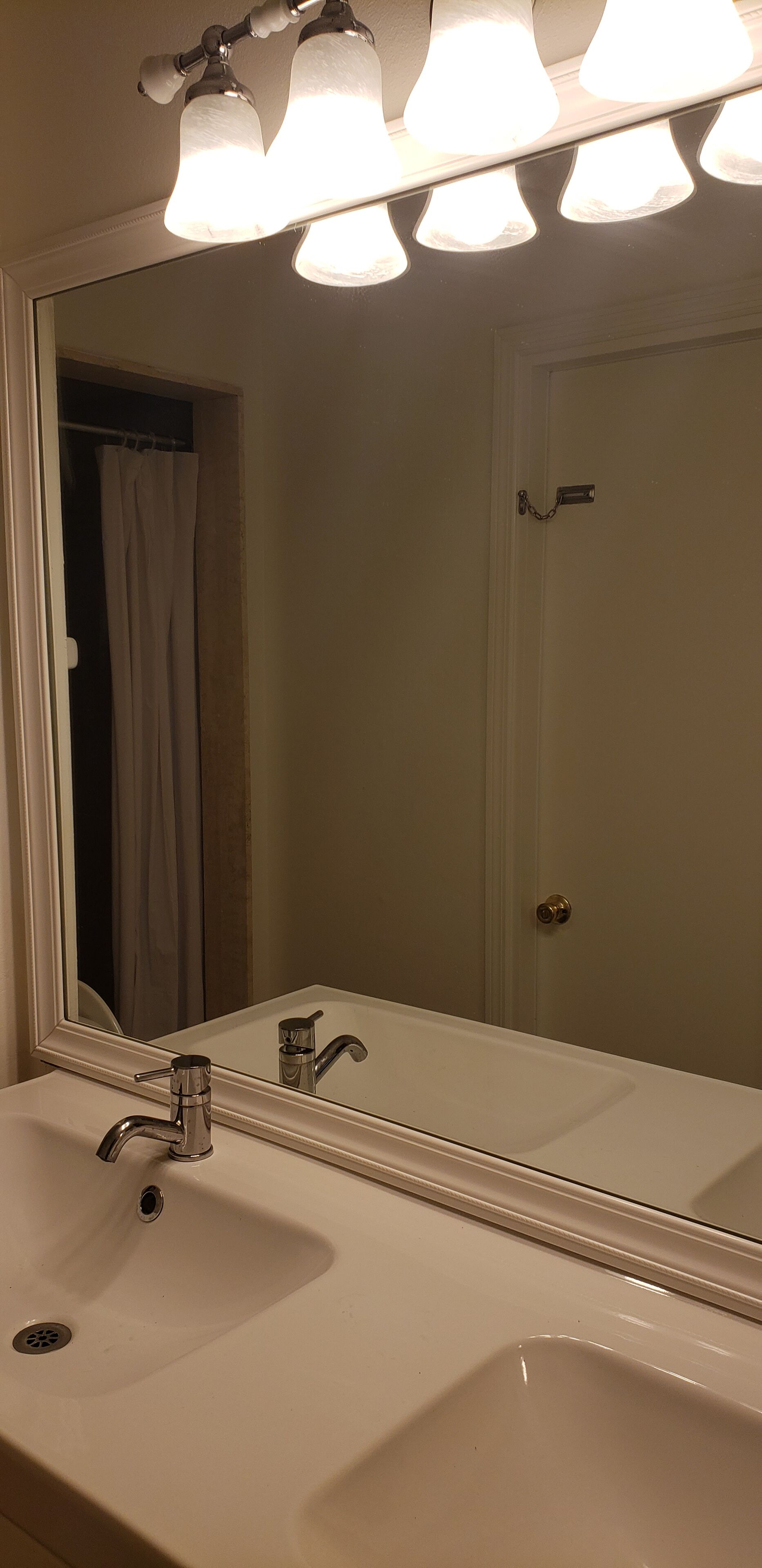 A bathroom with a white sink, a mirror, and a shower curtain.