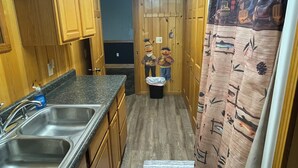 Une cuisine de taille réduite, dotée d’armoires en bois, d’un plan de travail en granit et d’un évier.