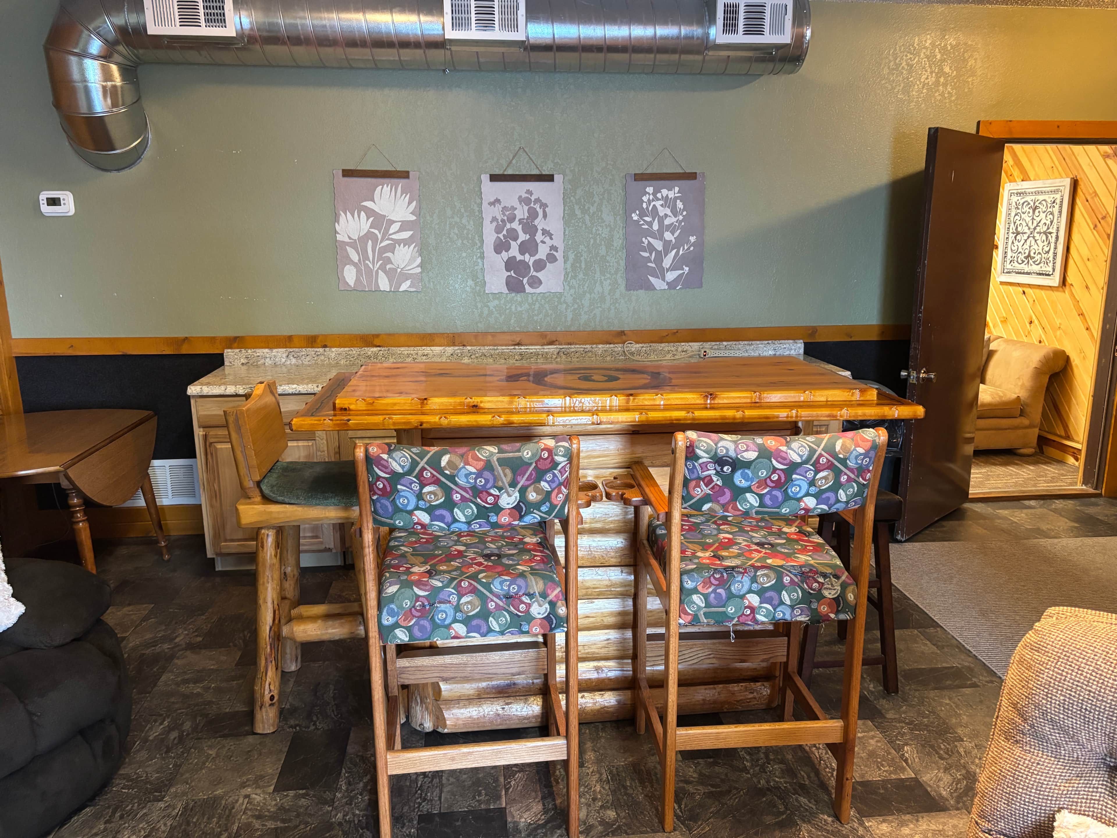 Interior de restaurante con mobiliario de madera, una mesa central y paneles decorativos en la pared.