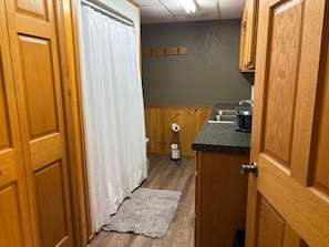 Een kleine keuken met houten kastjes, een aanrecht en een spoelbak.