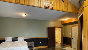 Une chambre à coucher comprenant un lit, une table de chevet, une armoire et une porte donnant sur une autre pièce.