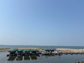 Een jachthaven met boten die afgemeerd liggen en overdekt zijn door groene luifels.