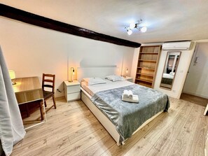 A bedroom with a bed, bedside tables, a desk, and a wardrobe. - Angle droite (Nice)