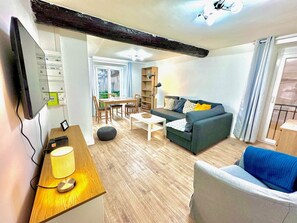 Ein modernes Wohnzimmer mit einer Couch, einem Couchtisch und einem an der Wand befestigten Fernseher.