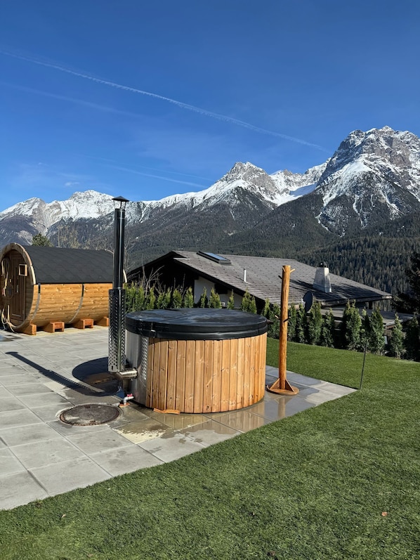 A hot tub in a landscaped area with a mountain backdrop.