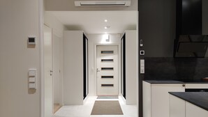 A modern kitchen with white cabinetry, a black countertop, and a recessed ceiling light. - Serviced Apts Rovaniemi Willamonkuja (Rovaniemi)