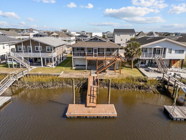 A residential area with houses, a dock, and a staircase leading to a second-story balcony.