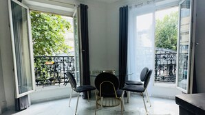 Un comedor moderno con suelo de mármol, una mesa redonda y sillas negras.