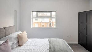 Une chambre à coucher avec un lit, une fenêtre et une armoire.