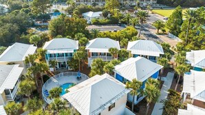 Un resort con varias edificaciones, piscina y abundante vegetación.