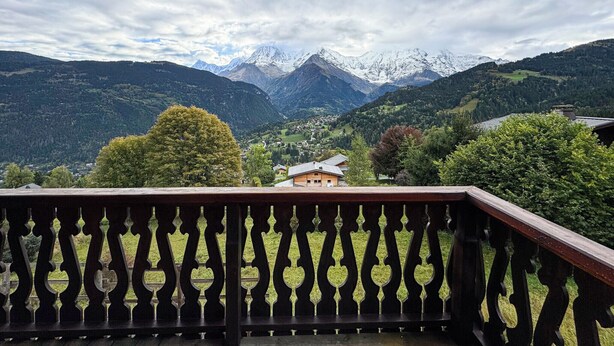 A balcony with a view of a mountainous landscape, including snow-capped peaks and a valley with houses. - Chalet facing Mont Blanc, calm and comfort (Saint-Gervais-les-Bains)
