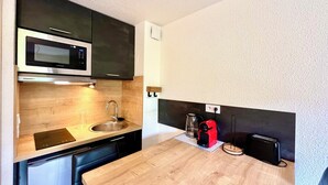 A compact kitchen with a microwave, sink, and a small coffee maker. - Le Refuge des Skieurs (Combloux)
